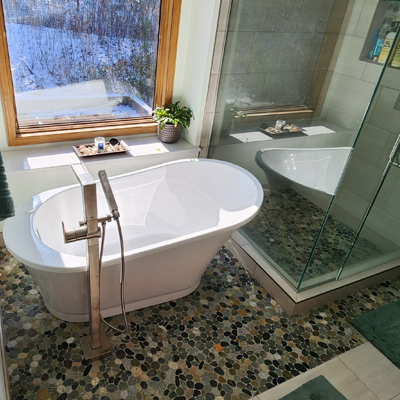 Bathroom remodel featuring a bathtub, custom shower and stone tile.